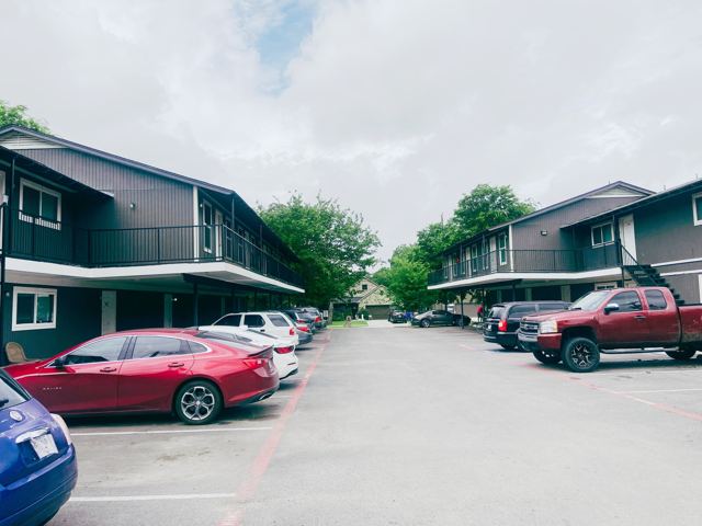 Two-story apartment buildings and resident parking at Legacy Apartments in Sherman, TX
