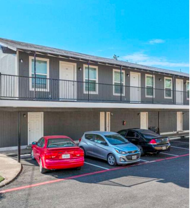 Two-story building with private apartment entries and parking in front